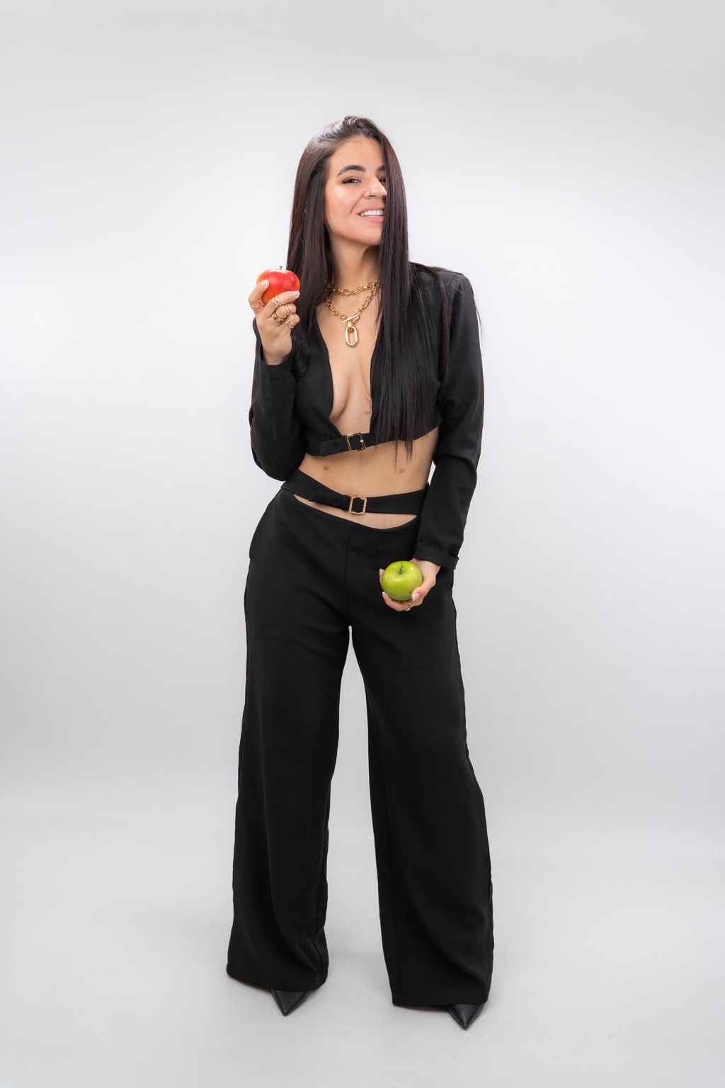 Manuela Espinosa sonriendo y sosteniendo una manzana roja y una verde